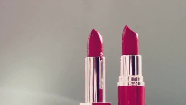 Kaksi vaaleanpunaista huulipunaa ja loistavat valosoihdut, ylellinen meikkituote ja loma kosmetiikka kauneusbrändille - Materiaali, video