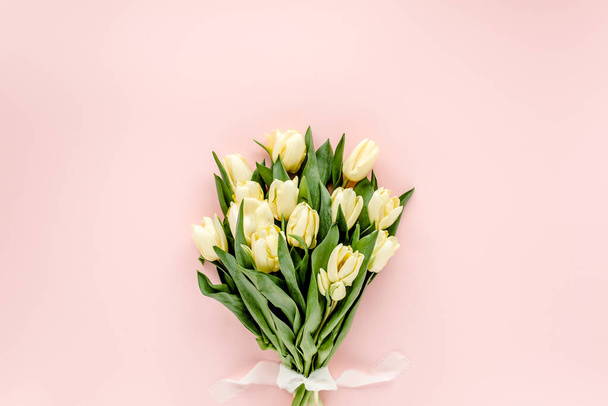 Ramo de flores de tulipán pastel y amarillo sobre fondo rosa. Asiento plano, vista superior. Fondo de San Valentín. Patrón floral - Foto, Imagen