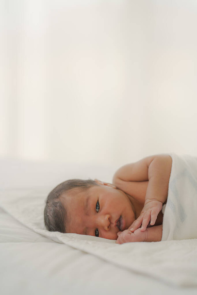 african american new born baby lying on white bed - Zdjęcie, obraz