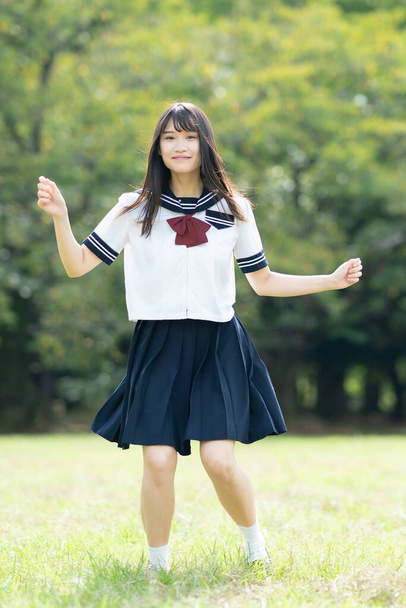 Ázsiai középiskolás lány szórakozás egy mosollyal a parkban - Fotó, kép