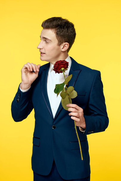 Úriemberek klasszikus öltöny sárga háttér és vörös rózsa romantika vágott nézet modell portré. - Fotó, kép