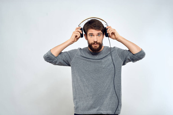 Человек в наушниках слушает музыку образ жизни современный стиль технологии светлый фон - Фото, изображение