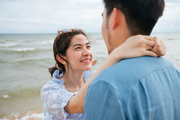 Romántico asiático pareja viajero mirando el uno al otro ojos en la playa. - Foto, imagen
