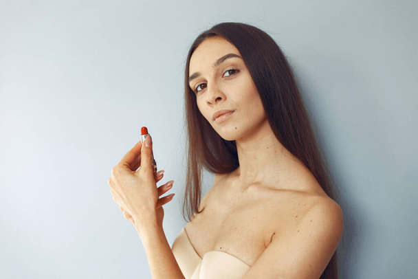 Beautiful girl standing in a studio with red lipstick - Foto, Bild