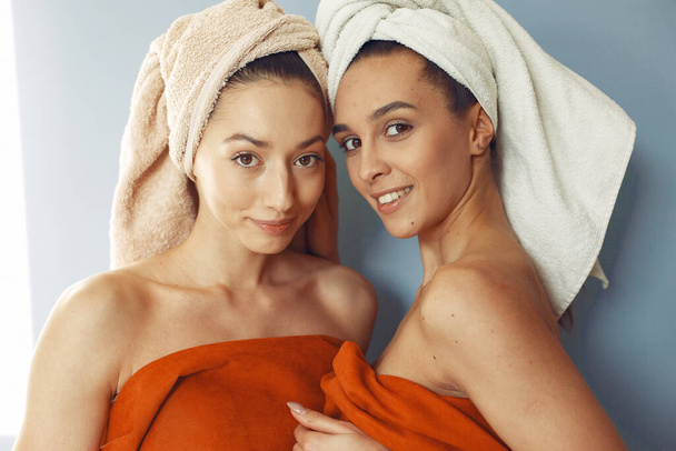 Beautiful girls standing in a studio with towel - Foto, imagen