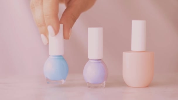 Розовый продукт сцены красоты, женские руки и ногтей бутылки для французского маникюра, красочный пастельный лак для ногтей на мраморном столе, макияж и косметический бренд - Кадры, видео