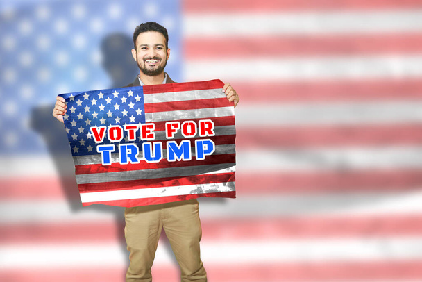 Ik stem troef, jongeman met Amerikaanse vlag, presidentskandidaat voor de presidentsverkiezingen van 2020, Amerikaanse politiek. kopieerruimte - Foto, afbeelding