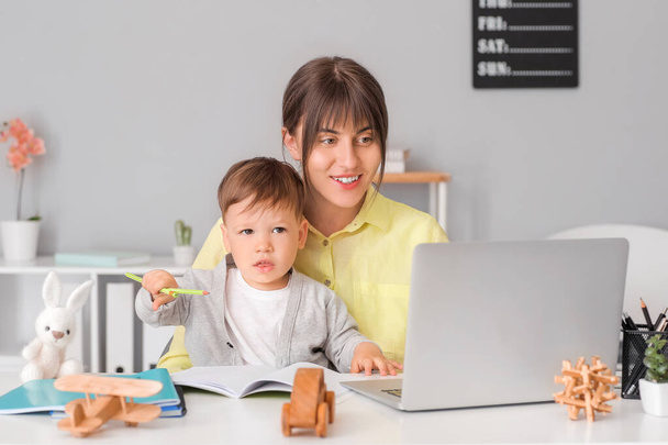 Pracující matka s malým synem v domácí kanceláři - Fotografie, Obrázek