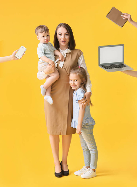 Berufstätige Mutter mit kleinen Kindern und viel Arbeit am farbigen Hintergrund - Foto, Bild