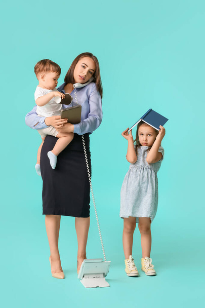 Работающая мать с непослушными детьми на цветном фоне - Фото, изображение