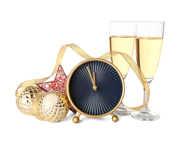 Budzik, świąteczny wystrój i kieliszki szampana na białym tle - Zdjęcie, obraz