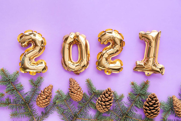 Balloons in shape of figure 2021 and fir branches on color background. New Year celebration - Photo, Image