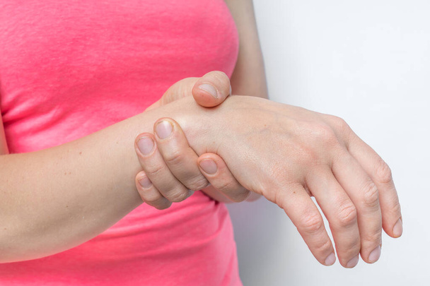 手首の痛みを持つ女性は彼女の痛みの手を保持しています – 体の痛みの概念 - 写真・画像