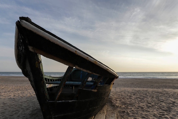 Hermoso naufragio de velero abandonado junto a la playa en Costa da Caparica durante una dramática puesta de sol con nubes dispersas sobre el Océano Atlántico. Lisboa, Portugal, 2020 - Foto, imagen