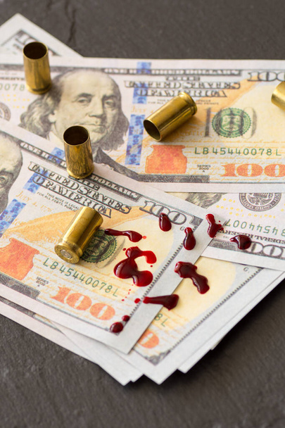 Yüz dolarlık banknotlara ve ateşli silahlara kan tükürmek suç para konseptini bozar. - Fotoğraf, Görsel