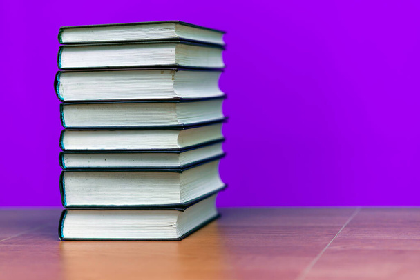 stack of old books, grungy background, free copy space trendy purple color background - Photo, Image