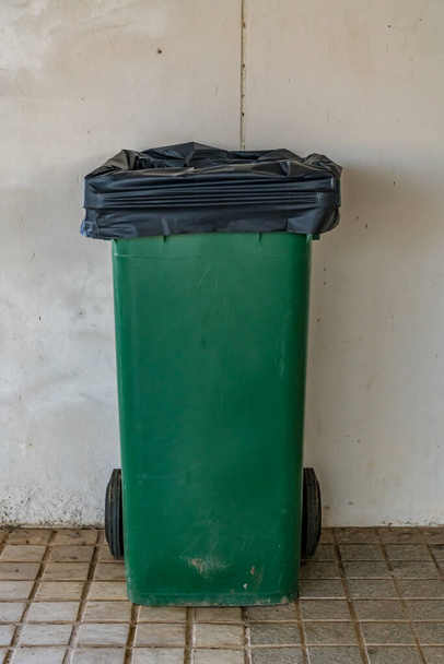 lata de lixo verde no fundo da parede de concreto - Foto, Imagem
