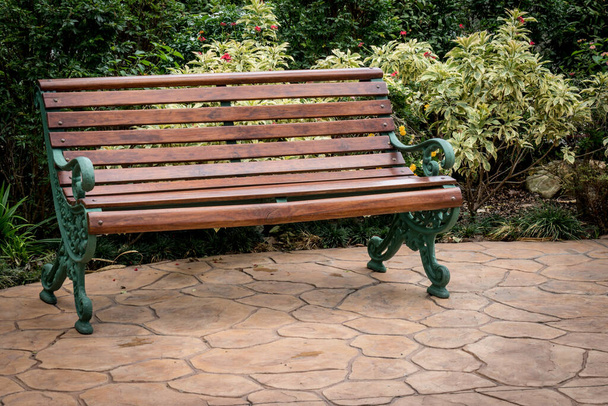 Ξύλινο παγκάκι σε τσιμεντένιο δάπεδο στον κήπο - Φωτογραφία, εικόνα