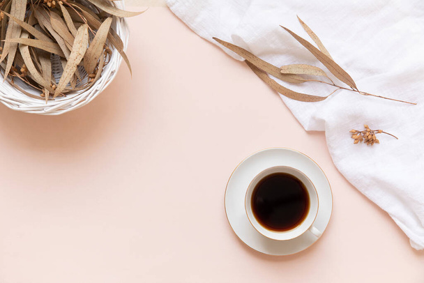 Foglie di eucalipto e una tazza di caffè nero su uno sfondo chiaro con spazio vuoto. - Foto, immagini