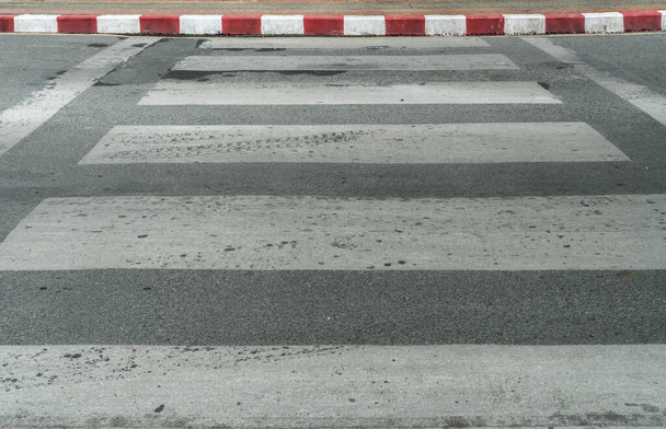 Άδεια διάβαση σε ασφαλτοστρωμένο δρόμο με κόκκινη και άσπρη πινακίδα στο πεζοδρόμιο - Φωτογραφία, εικόνα