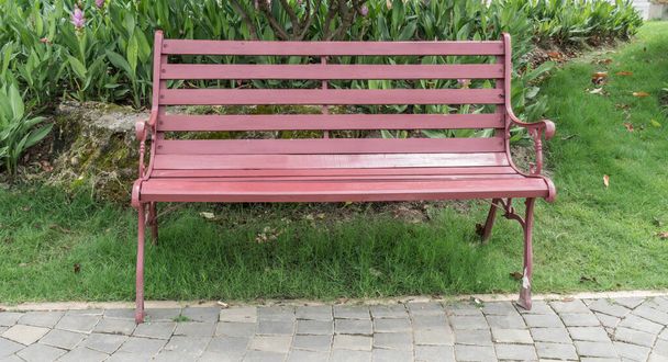 Metal park bench on concrete floor in garden - Photo, Image