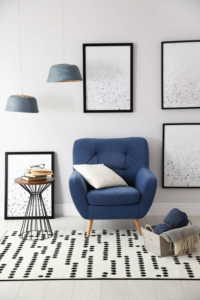 Beautiful artworks and comfortable armchair in stylish room. Interior design - Foto, Imagem