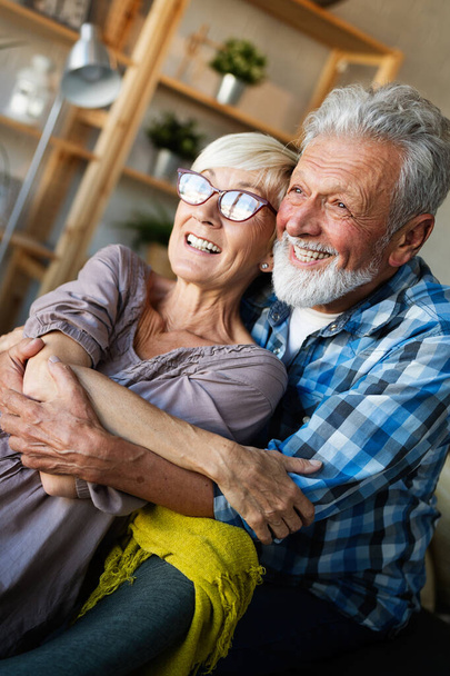 Happy romantic mature couple hugging and enjoying retirement at home - Photo, image
