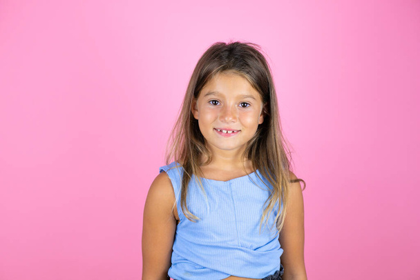 jong mooi kind meisje over geïsoleerde roze achtergrond glimlachen en kijken naar de camera - Foto, afbeelding