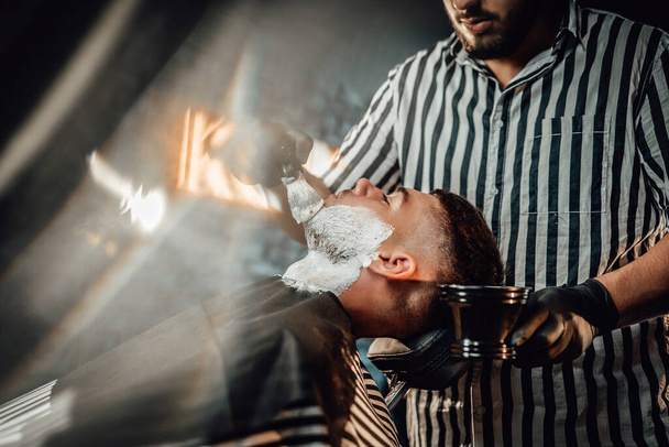 Nowoczesny i stylowy salon fryzjerski służy ulubionemu klientowi - Zdjęcie, obraz