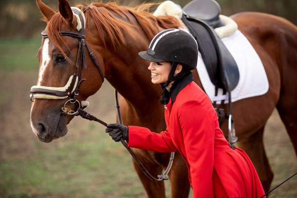 Kaunis nainen ratsastaja jockey halaa hänen hevonen - Valokuva, kuva