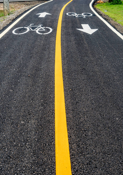 Aszfaltozott kerékpárút sárga vonallal és kerékpársávjelzéssel - Fotó, kép