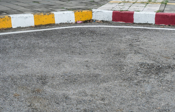 Δρόμος ασφάλτου με κίτρινη κόκκινη και λευκή πινακίδα κυκλοφορίας στο πεζοδρόμιο - Φωτογραφία, εικόνα