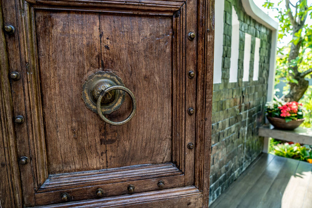 古いスタイルの鉄ハンドルと茶色の木製のドア - 写真・画像