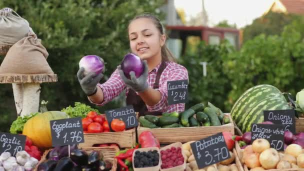 Teen girl offers to buy eggplants at the farmers market - Footage, Video
