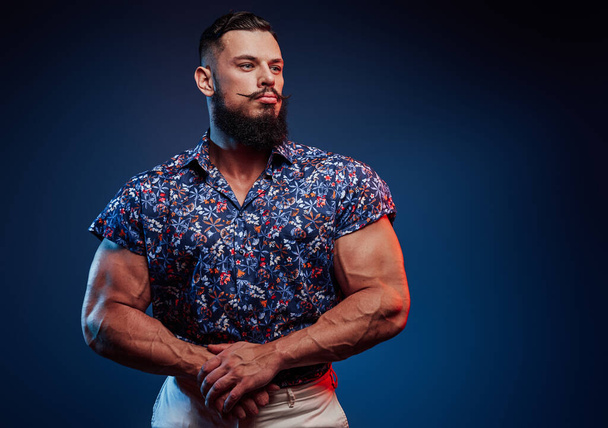 Bearded bodybuilder in casual clothing posing in blue background - Photo, Image