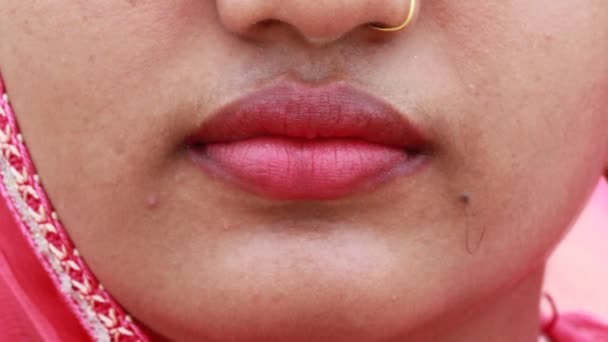 closeup λεπτομέρειες για ένα όμορφο ινδικό γυναικείο μοντέλο μόδας ή κομψό νεαρή γυναίκα παίρνει μαλακό πανέμορφα χείλη της Δίνει ένα γοητευτικό βλέμμα με ροζ κραγιόν με το χέρι - Πλάνα, βίντεο