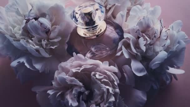 Purple perfume bottle with peony flowers, chic fragrance scent as luxury cosmetic, fashion and beauty product background - Footage, Video