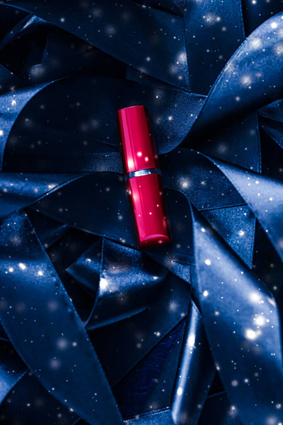 Lápiz labial rojo sobre seda azul y brillante fondo de brillo, maquillaje de lujo y cosméticos de belleza - Foto, Imagen