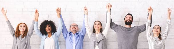 Группа счастливых людей, держащихся за руки, поднимающих руки, панорама - Фото, изображение