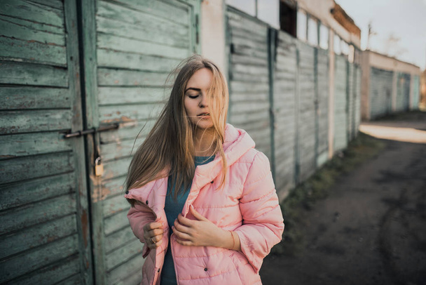 Nuori upea blondi tyttö pukeutunut muoti vaaleanpunainen takki ja sininen farkut - Valokuva, kuva
