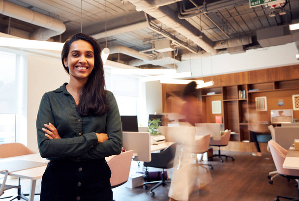 Retrato de mulher de negócios sorridente em pé no escritório moderno ocupado do plano aberto - Foto, Imagem