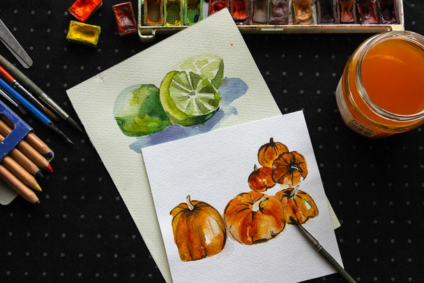 Pumpkin painting vegetable flat lay composition on table. Dark wooden table with watercolor paints brushes and artwork. Watercolor card. - Photo, Image