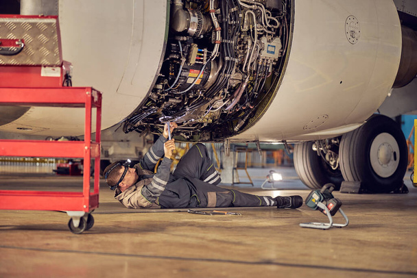 Bodenpersonal arbeitet unter einem Passagierflugzeug - Foto, Bild