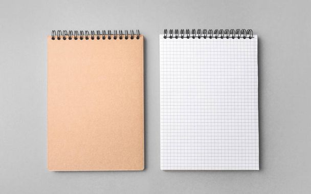 Cuadernos en espiral en blanco sobre fondo gris. Vista superior. - Foto, Imagen