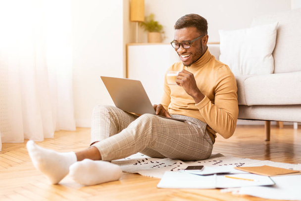 Hombre alegre trabajando en el ordenador portátil sentado en casa, enfoque selectivo - Foto, Imagen