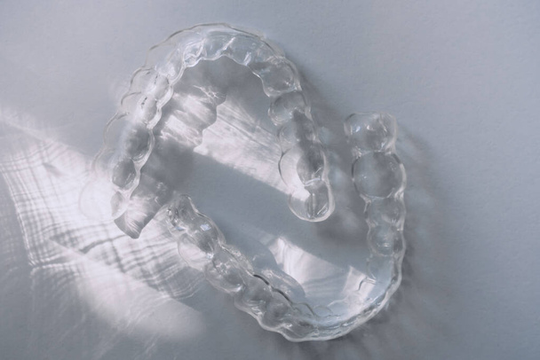 Moderne tand transparante uitlijnaars of beugels om tanden in cosmetische tandheelkunde en orthodontie rechtzetten met trendy schaduwen, selectieve focus - Foto, afbeelding