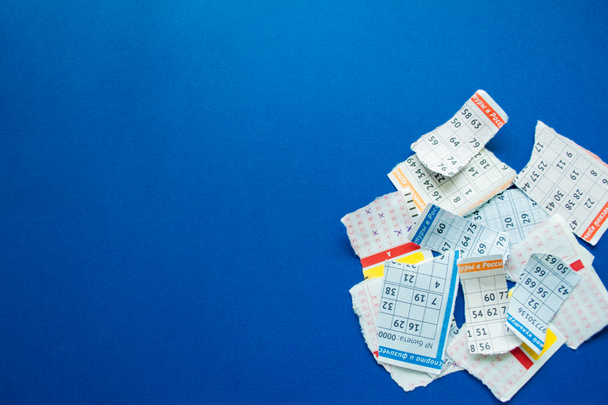 Torn lottery tickets with numbers on a dark blue background. Copy space. The concept of losing money and luck. - Photo, Image