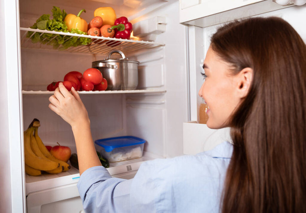 冷蔵庫から有機野菜を取る若い主婦 - 写真・画像