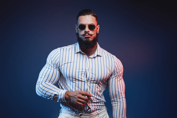 Elegance bodybuilder in shirt posing with cigar in hand - Photo, Image