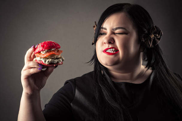 portrait attractive fat woman eating red hamburger - Фото, изображение